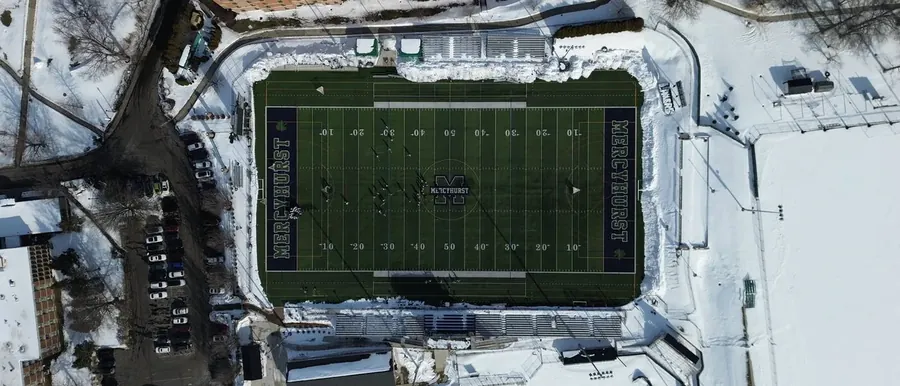 University stadium photographed from directly above under snow