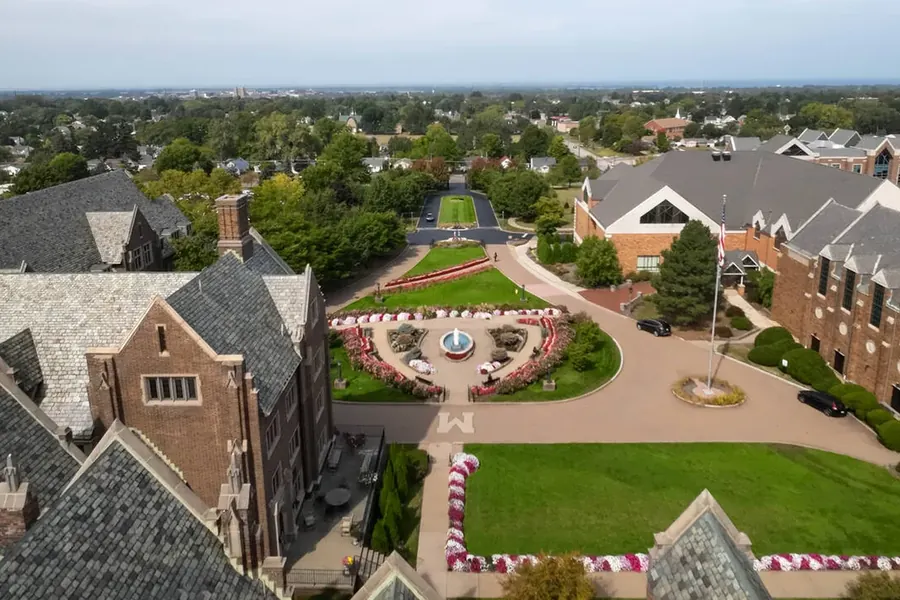 The same courtyard and fountain in summer, flowerbeds in bloom
