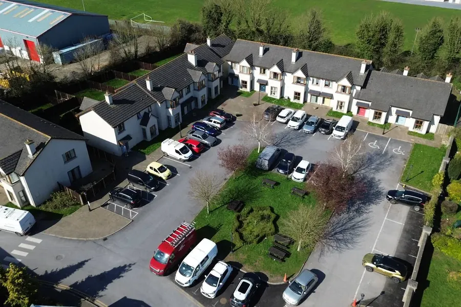 White terraced buildings and courtyard parking seen from the air