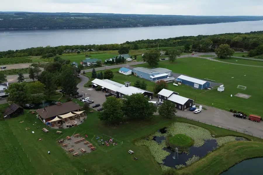 Lakeside farm with white barns photographed from the air